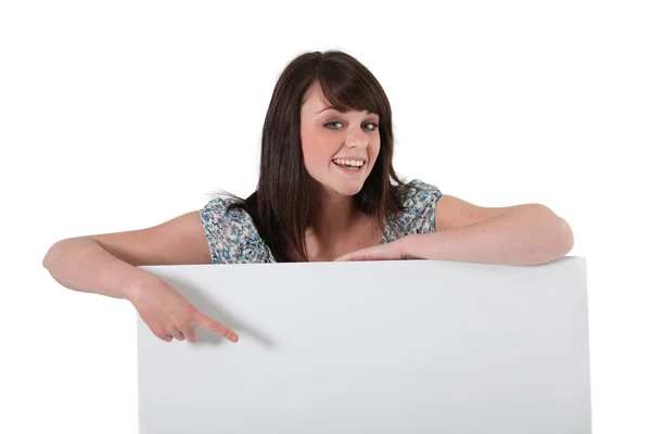 Woman pointing to blank poster — Stock Photo, Image