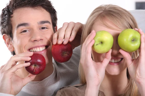 Engraçado casal segurando maçãs — Fotografia de Stock