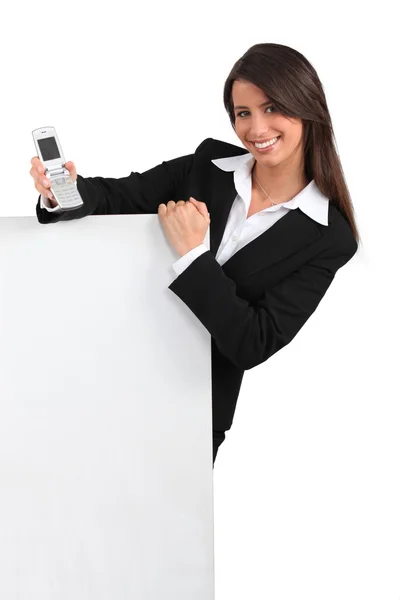 Sorrindo jovem inteligente com um telefone fliptop e uma placa em branco pronto para o seu texto ou imagem — Fotografia de Stock