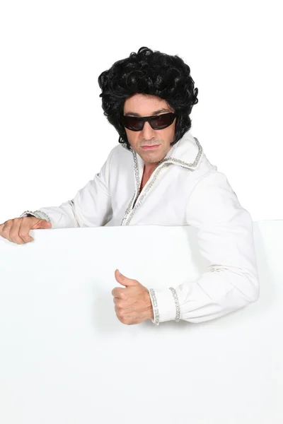 Mann als Elvis verkleidet mit leerer Anzeigetafel — Stockfoto