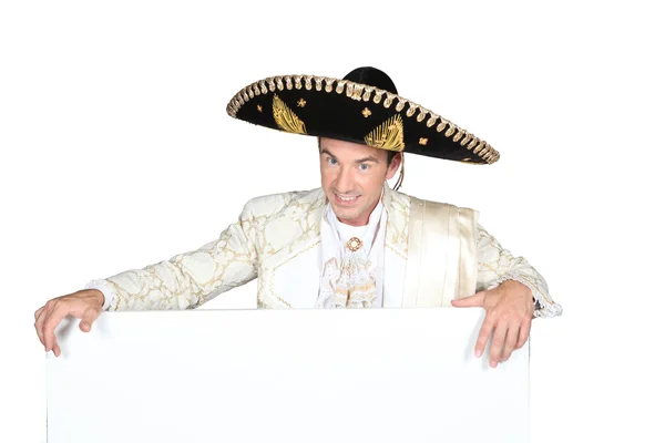 Man in een mariachi kostuum met een leeg bord links voor uw bericht — Stockfoto