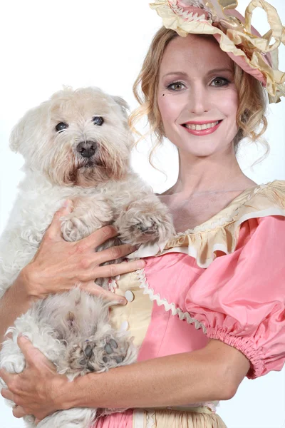 Pani w różowy i krem historycznych sukienka trzyma mały biały pies — Zdjęcie stockowe