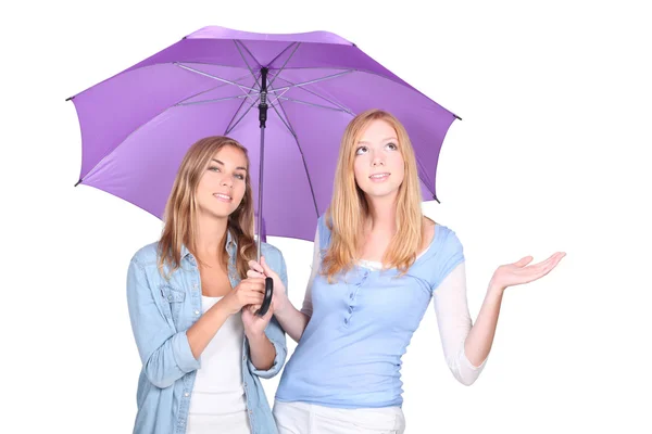 Deux jeunes femmes blondes sous un parapluie, l'une d'elles lève les yeux et tend la main — Photo