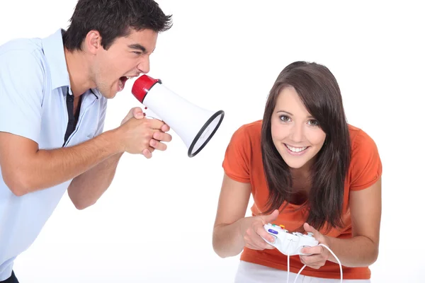Άνθρωπος ουρλιάζοντας στην bullhorn ενώ γυναίκα παίζει βιντεοπαιχνίδια — Φωτογραφία Αρχείου