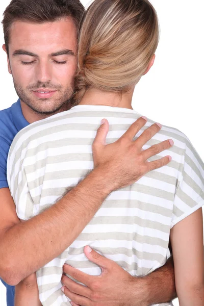 Homem de olhos fechados abraçando uma loira — Fotografia de Stock