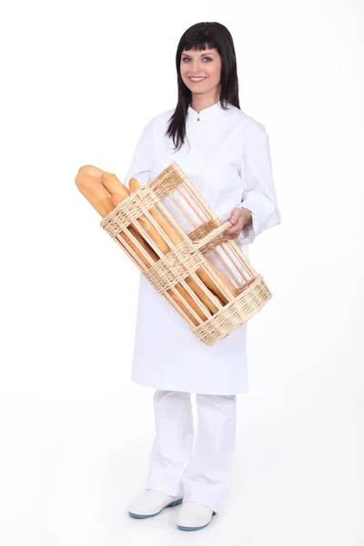 Panettiere con un cesto di baguette — Foto Stock