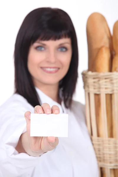Bakery worker holding out business card — Stock Photo, Image