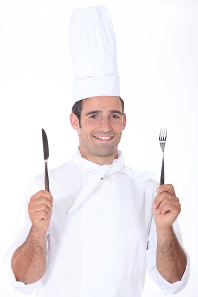 Chef en blanco sosteniendo un cuchillo y tenedor —  Fotos de Stock