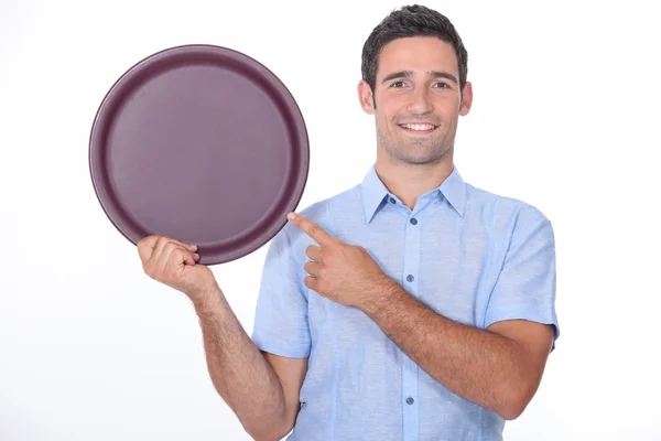 Smiling man pointing at an empty drinks tray — Stock Photo, Image