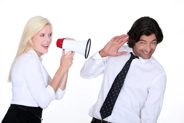 A blonde woman yelling on a man with a megaphone — Stock Photo, Image