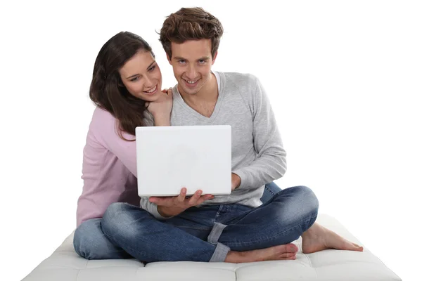 Jongen en meisje met behulp van laptop zat op een bank — Stockfoto
