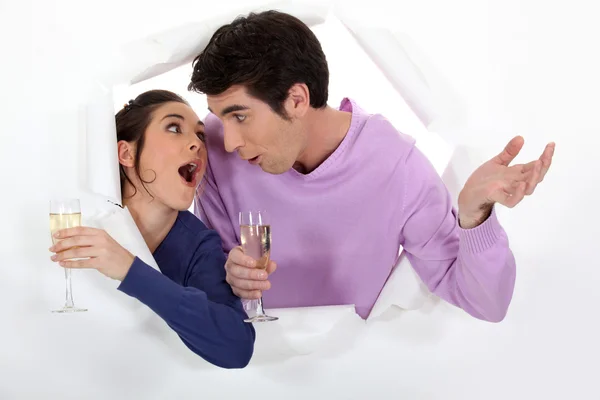 Mann und Frau amüsieren sich mit einem Glas Champagner in der Hand — Stockfoto