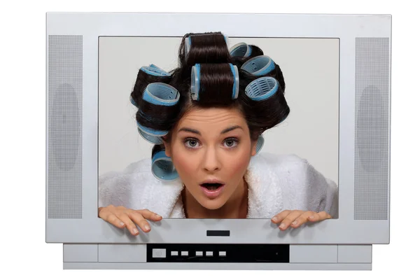 Vrouw in tv-toestel met haar krulspelden — Stockfoto
