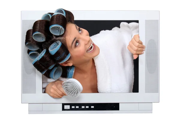 Woman popping out the TV with hairroller on. — Stock Photo, Image