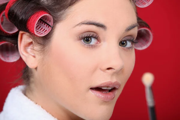 Portrait of woman with curlers and brush in hand — Stock Photo, Image