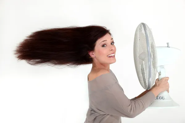 Женщина с электрическим вентилятором — стоковое фото