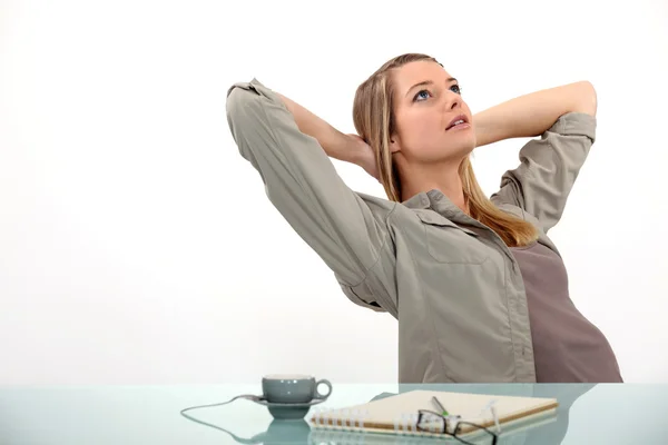 Frau entspannt sich am Schreibtisch — Stockfoto