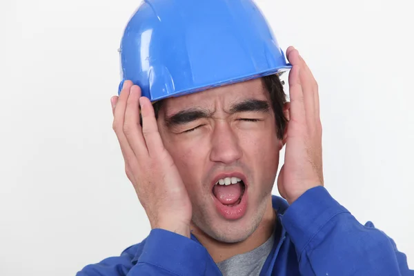 En ung manuella arbetstagare hörsel outhärdlig buller. — Stockfoto