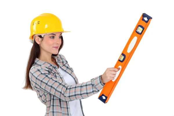 Ženské stavební dělník drží úroveň. — Stock fotografie