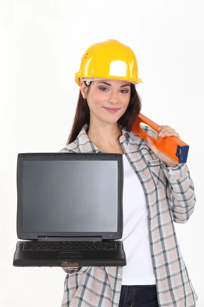 Kvinnlig builder innehar en laptop med en tom skärm — Stockfoto