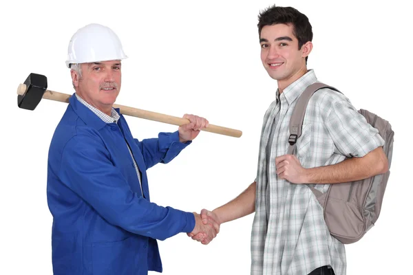 Senior craftsman and apprentice shaking hands — Stock Photo, Image
