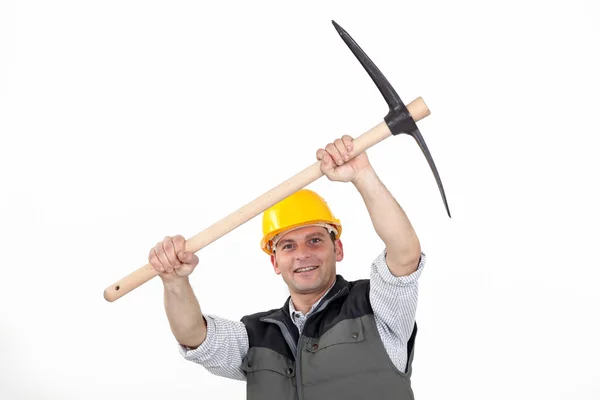 Trabalhador da construção civil carregando uma picareta — Fotografia de Stock