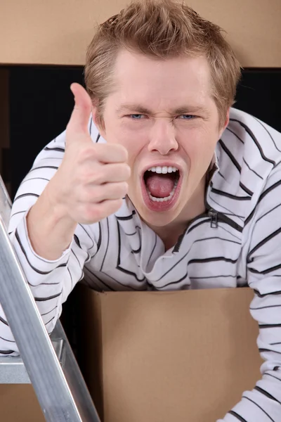 Thumbs up from a man with cardboard boxes — Stock Photo, Image