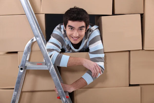Trabalhador da logística escondido entre caixas — Fotografia de Stock