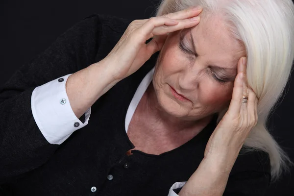 Older woman with a headache — Stock Photo, Image