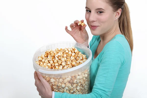 Frau isst Popcorn aus großem Eimer — Stockfoto