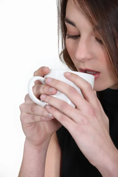 A brunette drinking coffee. — Stock Photo, Image