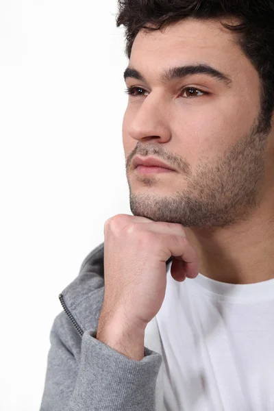 Pensive man stood touching chin with fist — Stock Photo, Image