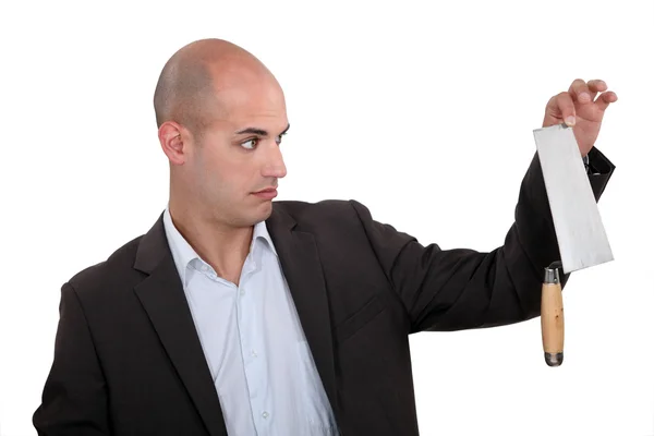 Unenthusiastic businessman holding trowel — Stock Photo, Image