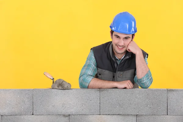 Мейсон, поддерживаемый бетонной стеной — стоковое фото