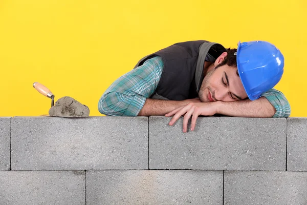 Építő alszik a falon — Stock Fotó