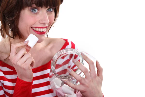 Frau isst Marshmallows aus einem Glas — Stockfoto