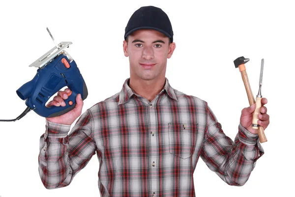 Man holding band-saw, hammer and chisel — Stock Photo, Image