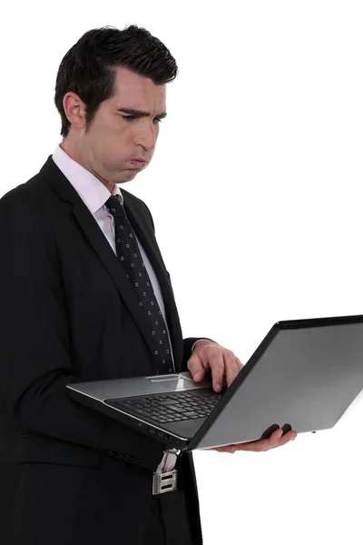 Ένας δυσαρεστημένος επιχειρηματίας με ένα φορητό υπολογιστή. — Φωτογραφία Αρχείου