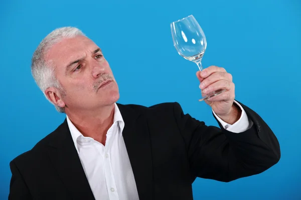 Muž zkoumání sklenice na víno — Stock fotografie