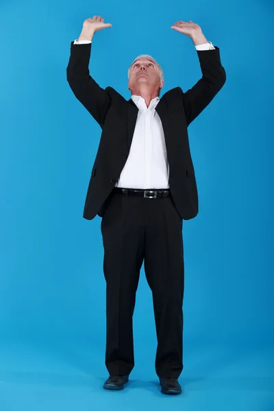 Senior businessman pushing upwards — Stock Photo, Image