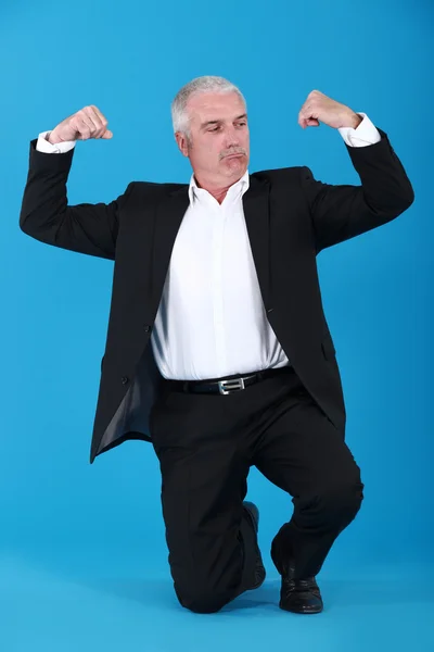 Homem de negócios maduro voando seus músculos — Fotografia de Stock