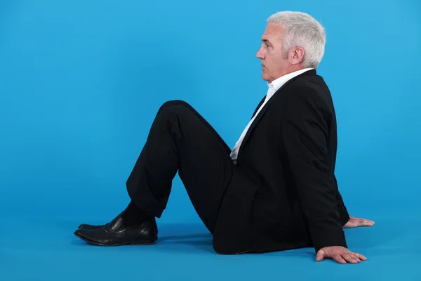 Oudere man zittend op de vloer — Stockfoto