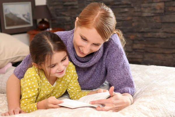Mãe ensinando filha a ler — Fotografia de Stock
