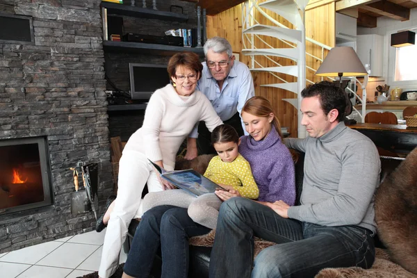 Familie leesboek op een sofa — Stockfoto