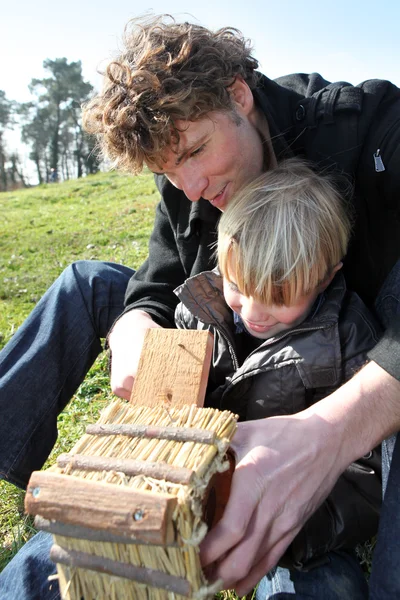 Отец и сын строят хижину для птиц — стоковое фото