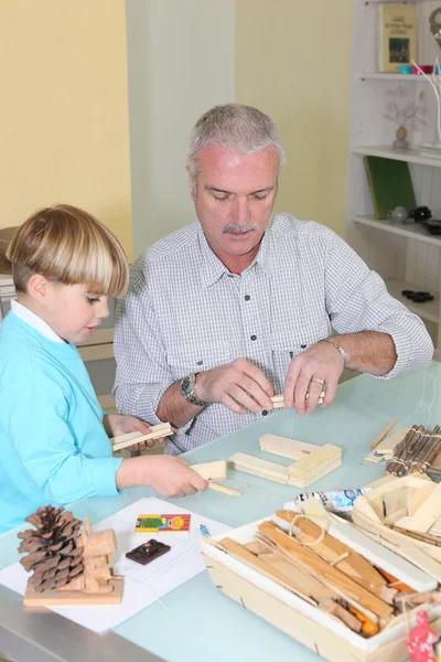 Vader en zoon bouwen een houten speelgoed — Stockfoto
