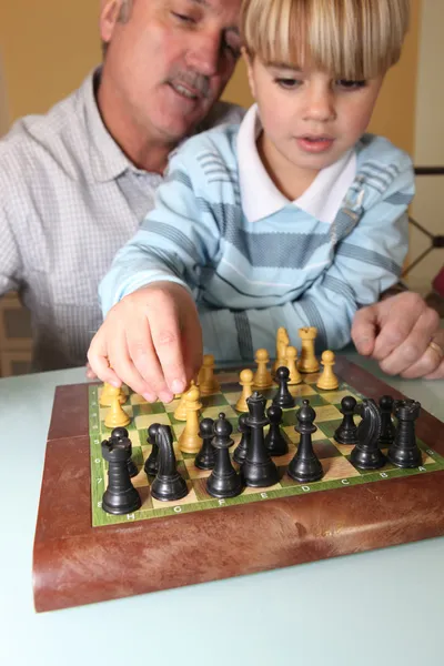 Старий грає в шахи зі своїм онуком — стокове фото