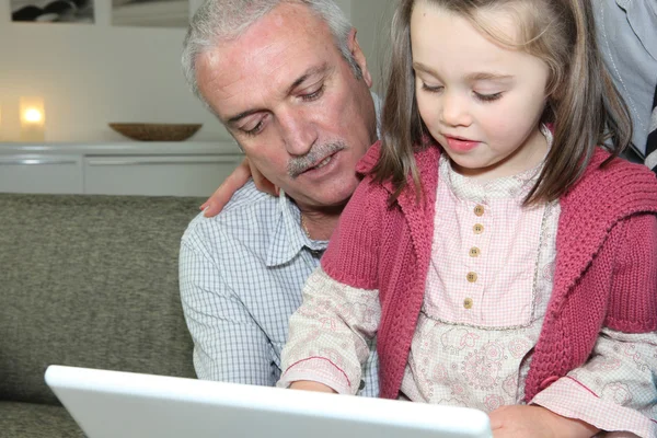Avô e menina com laptop — Fotografia de Stock