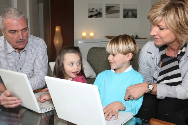 Mor-och farföräldrar med barn och bärbara datorer — Stockfoto