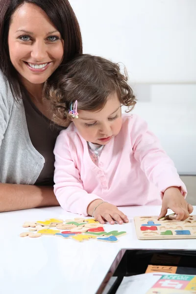 Matka s dcerou dělá puzzle — Stock fotografie
